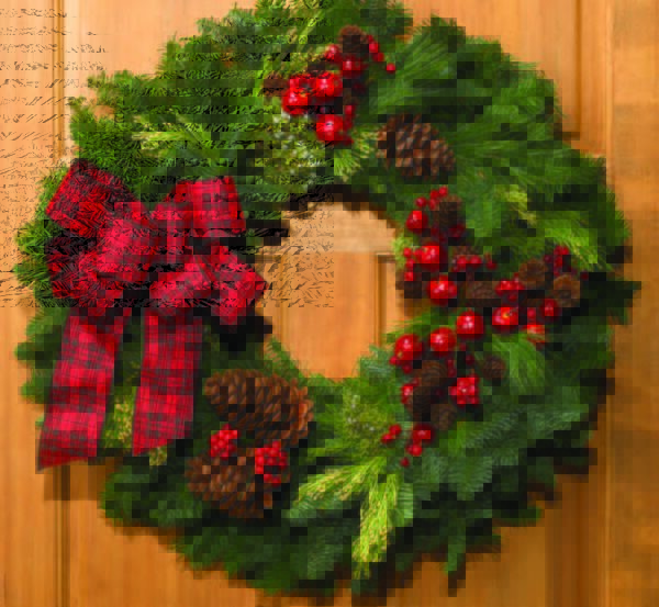 A Christmas wreath with red ribbons, pinecones, and red decor, using Oregon Wire's wreath ring.